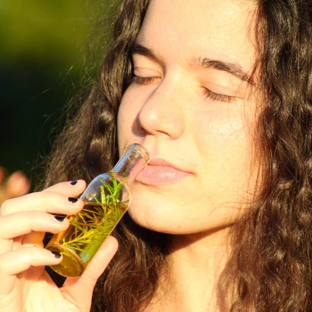 Amaia oliendo un frasco con aceite y hierbas