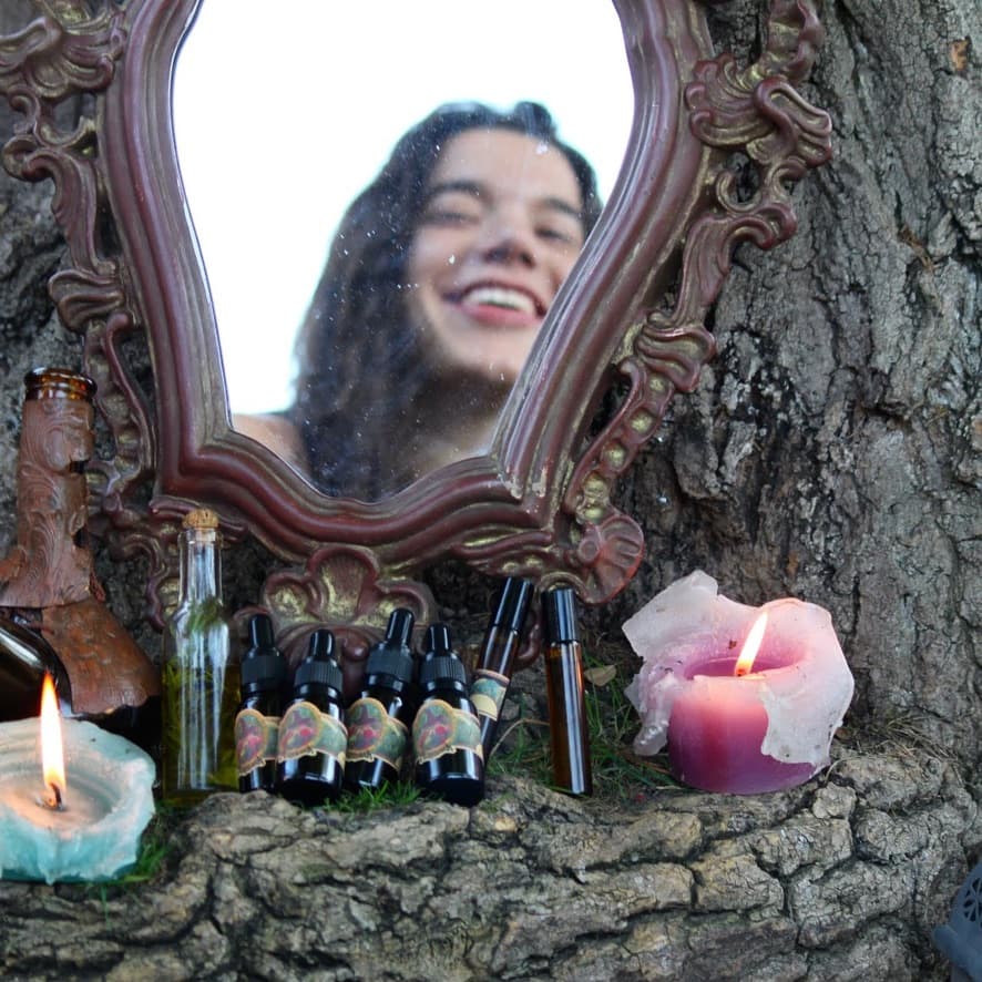 En un árbol, se ven frascos apilados, y Amaia reflejada en un espejo